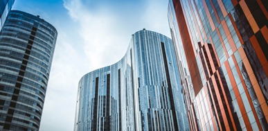 Modern office buildings with unique architecture against a blue sky. City skyline.