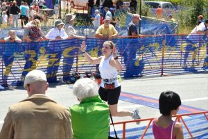 Marathon runner crossing finish line with cheering crowd