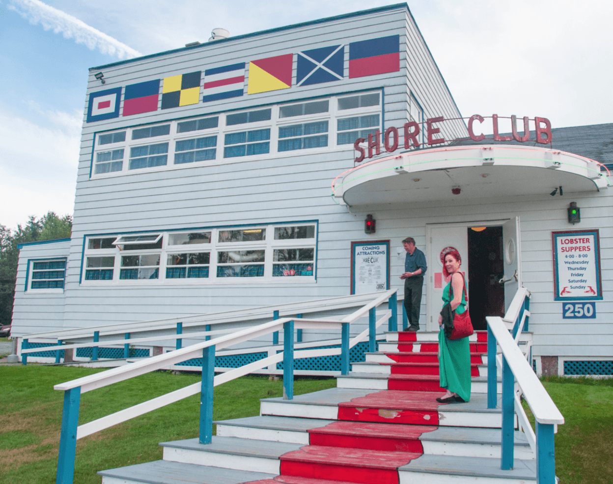 Shore Club building with nautical flags and people on the steps.