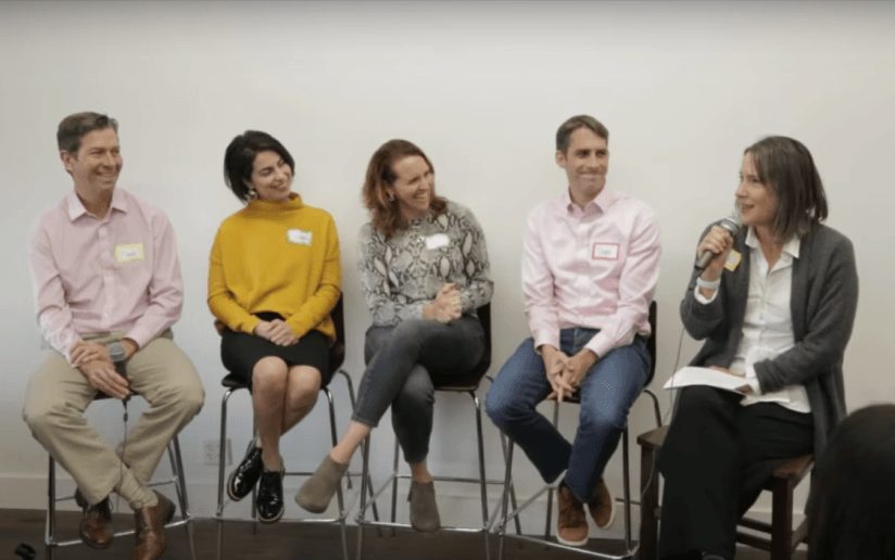 Panel discussion with consultants on stage, featuring diverse professionals.