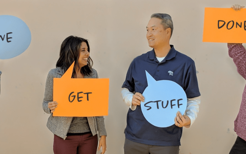 DEI teamwork: People holding signs that say "Get Stuff Done" during a diversity and inclusion initiative.
