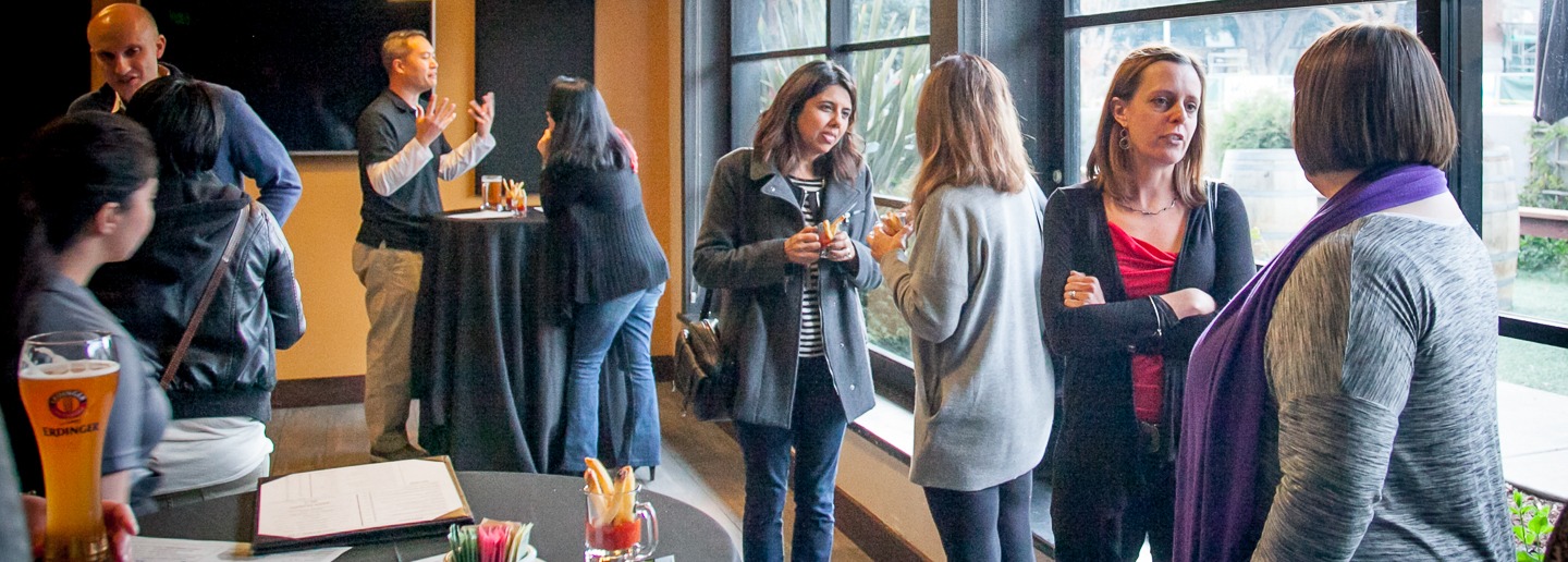 EM Marketing New Years party: People chatting and enjoying drinks at an event.