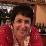 Smiling woman with short dark hair in a restaurant setting