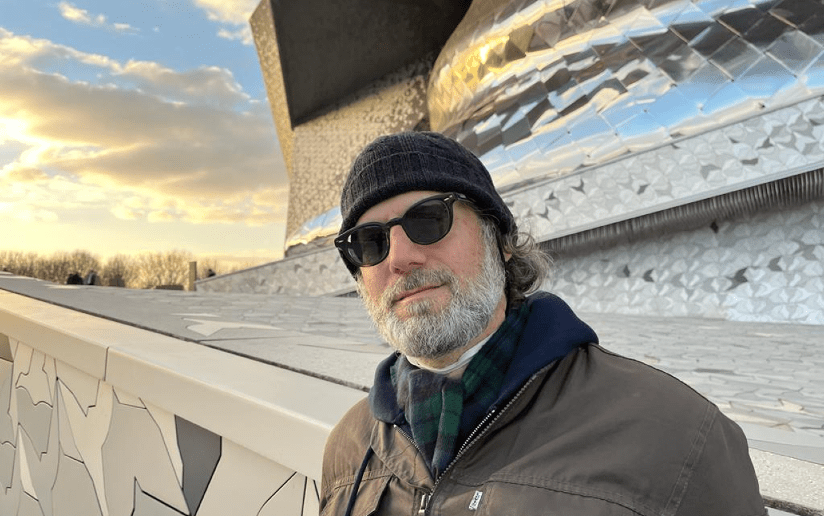 Ken Grobe, author, poses in front of the Philharmonie de Paris. The Write Stuff.