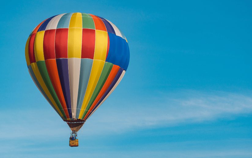 Colorful hot air balloon against a clear blue sky, symbolizing curiosity and creative B2B video ideas.