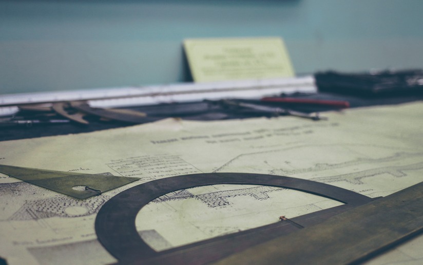 Architectural blueprint with drafting tools: ruler, protractor, and compass