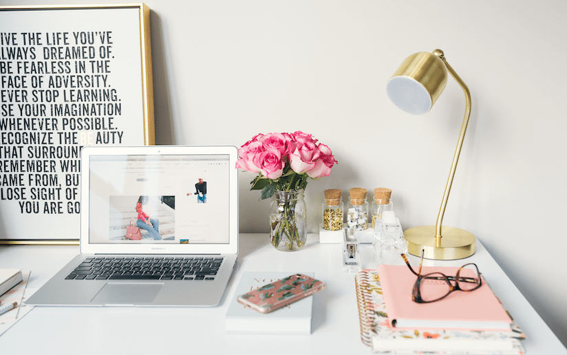Desk with laptop, pink roses, and inspirational quote: "Live the life you've always dreamed of.