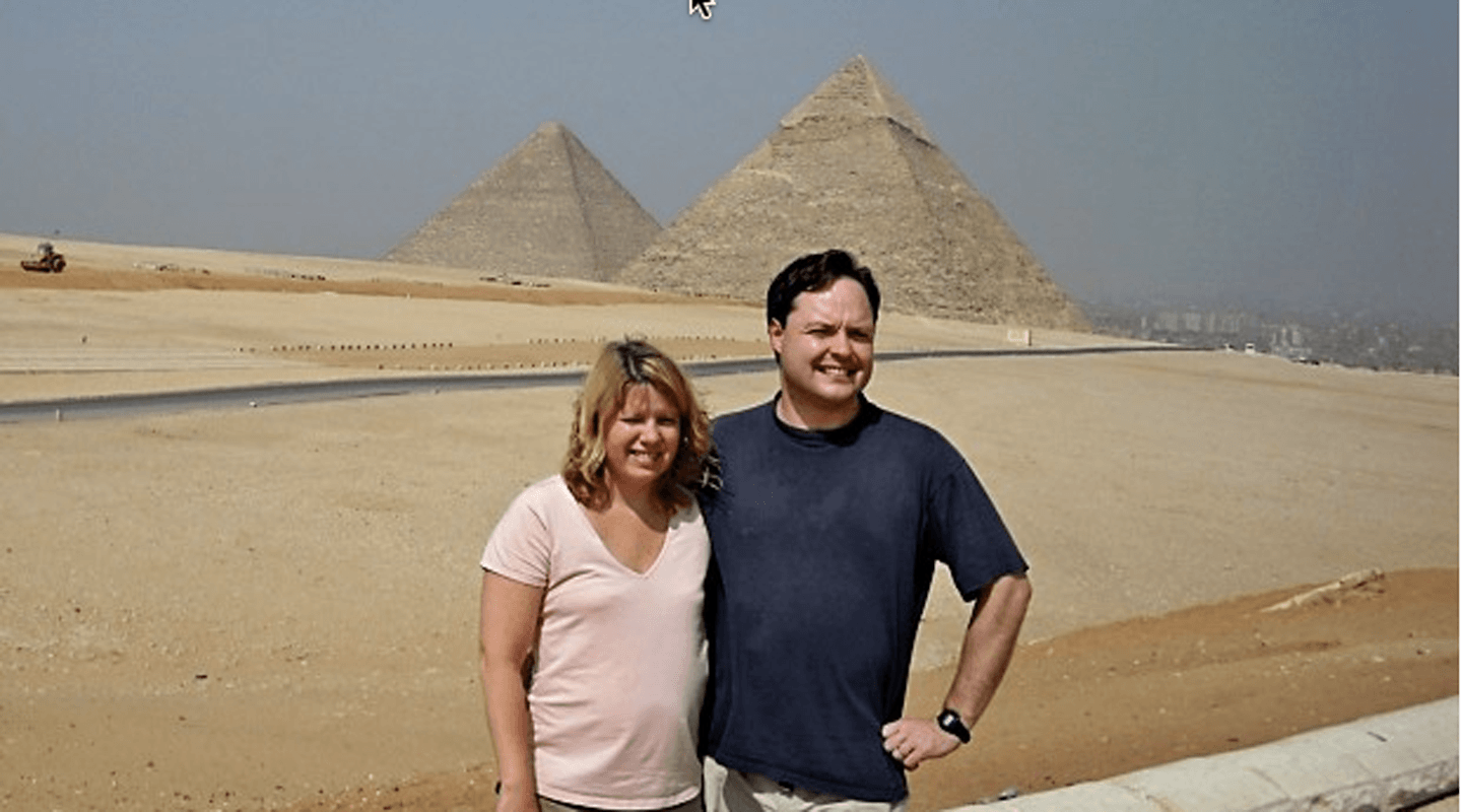 Couple poses in front of the Great Pyramids of Giza, Egypt.
