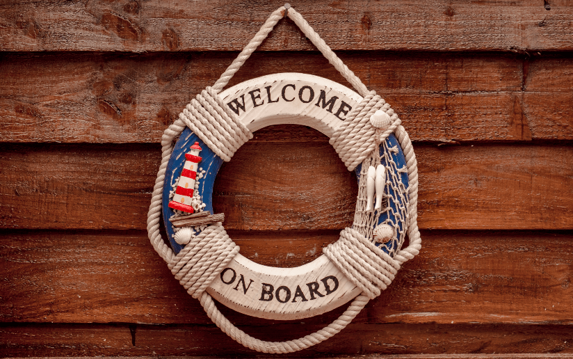 Nautical "Welcome On Board" life preserver decoration on a wooden wall.