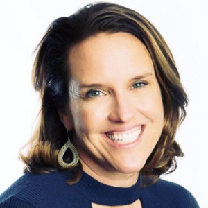 Smiling woman with brown hair and gold earrings
