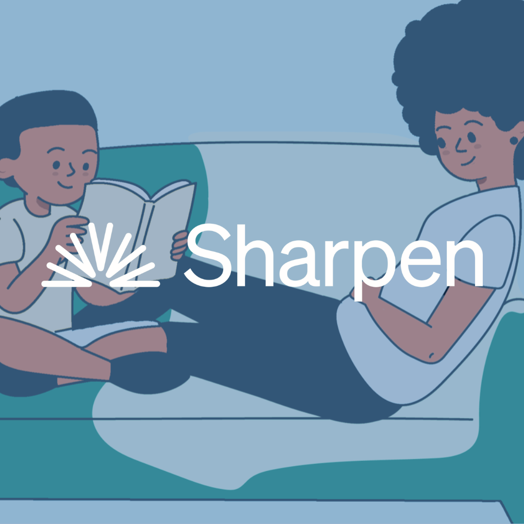 A child reading a book with an adult on a couch. Sharpen logo.