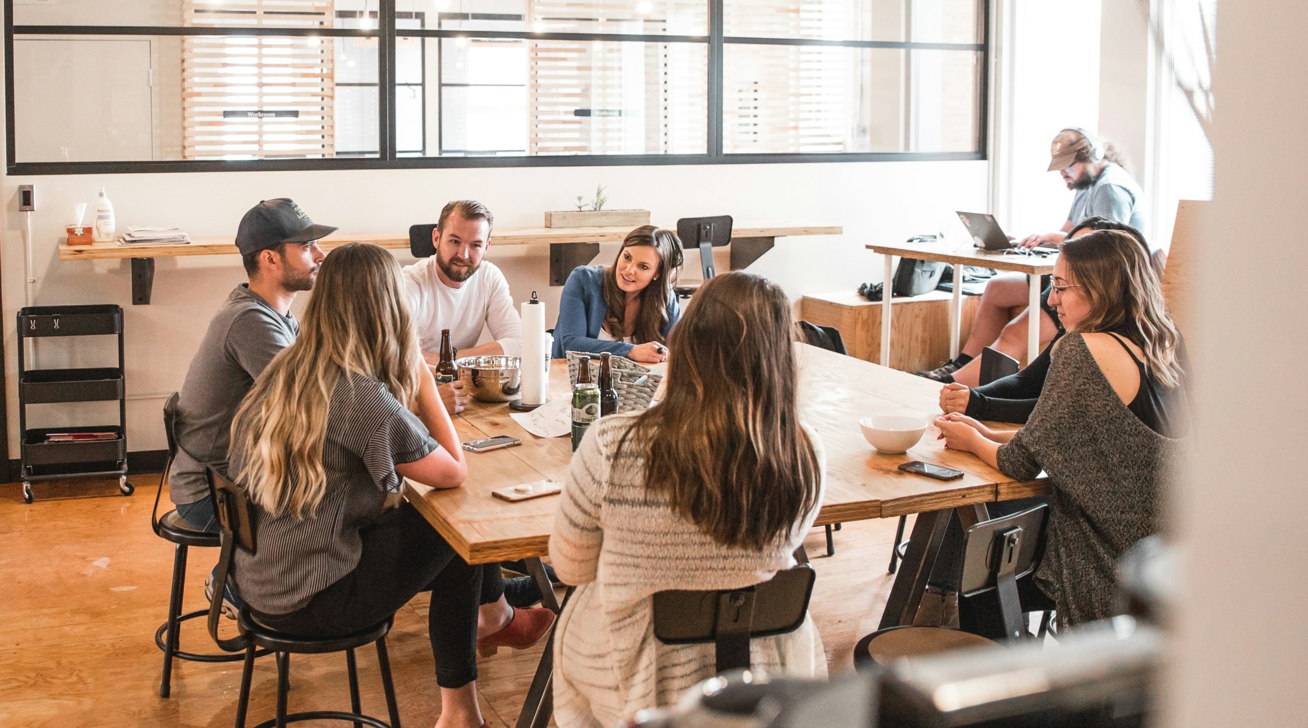 Group of people in a meeting, possibly discussing marketing strategies. Fractional CMO could help with this.