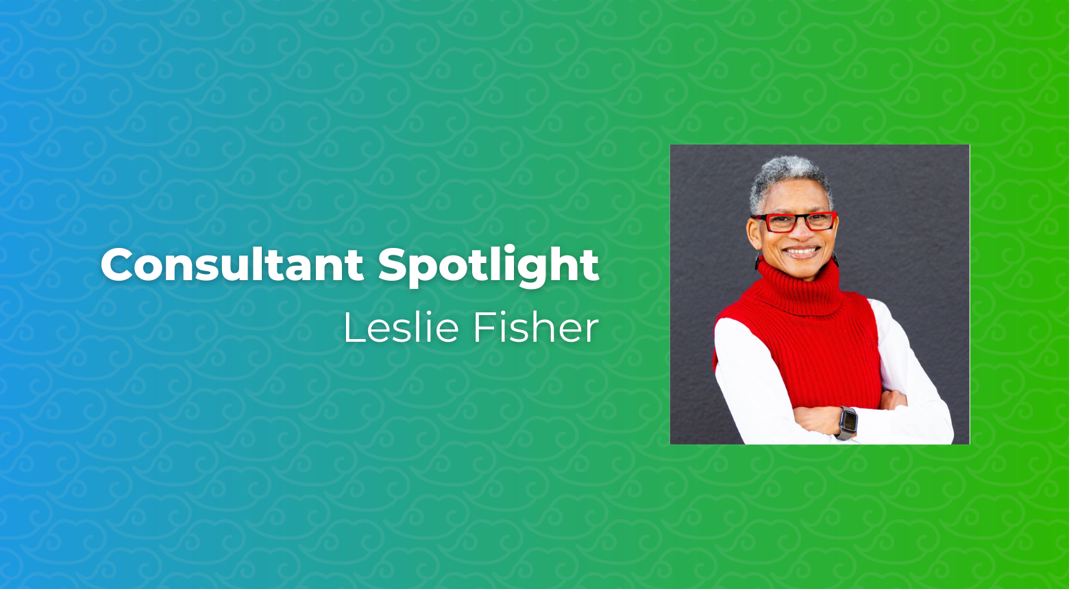 Consultant Spotlight: Leslie Fisher, wearing red glasses and a red sweater, smiles