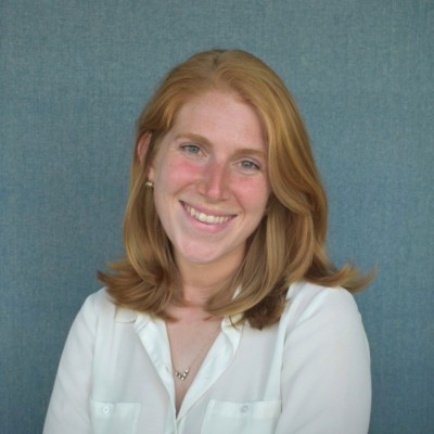 Young woman with red hair smiles, showcasing healthy skin, a benefit of Vitamin C